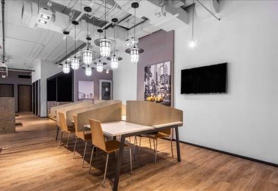 Modern coworking area with wooden desks and stylish pendant lighting.
