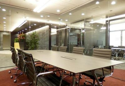 Professional boardroom with a large conference table and glass walls.