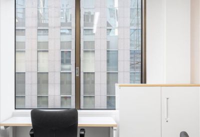 Private office workspace with a window overlooking the city skyline.
