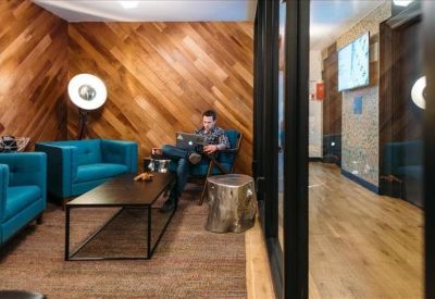 Comfortable lounge area with wood-paneled walls and teal armchairs.