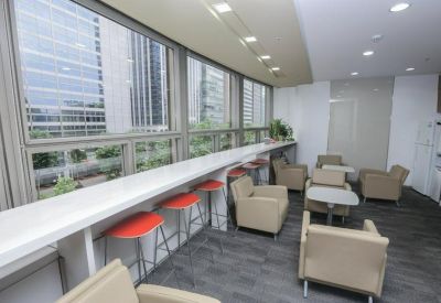 Lounge area featuring a long window-side breakfast bar with red stools and comfortable armchairs.