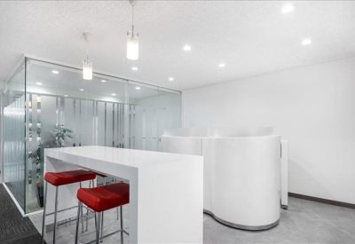 Bright modern breakout area with white high-top table and vibrant red stools.