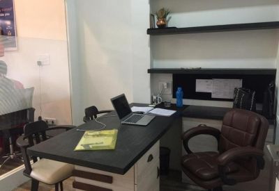 Professional private office desk with a leather chair and built-in shelving.