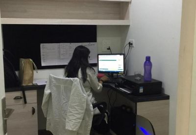 Compact workstation with a person working at a computer desk and overhead storage.