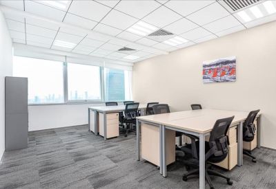 Bright open-plan office with multiple workstations and large windows.