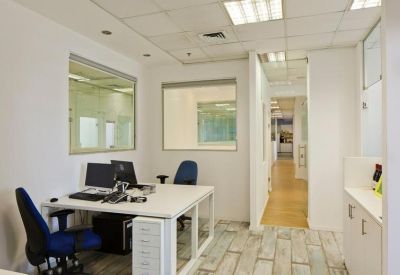 Private office suite with two workstations, ergonomic blue chairs, and large internal windows.
