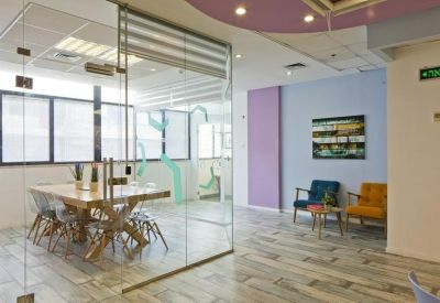 Spacious glass-walled conference room with a large wooden table and designer chairs.