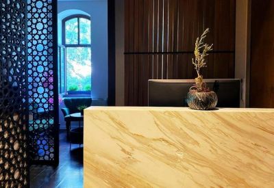 Elegant reception area with a marble-textured desk and a decorative lattice screen.