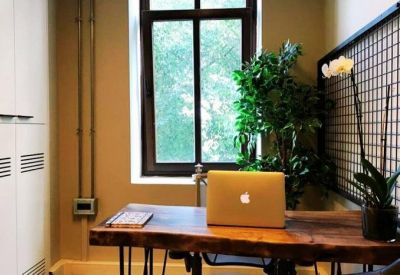 Private office featuring a live-edge wooden desk and a large window with green views.