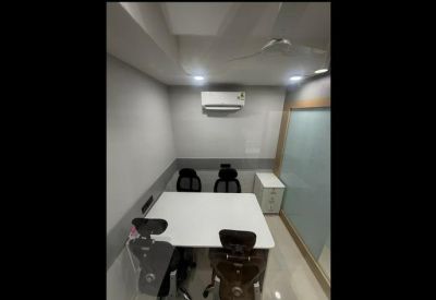 Private four-person office suite with white desks and overhead air conditioning.
