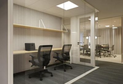 Bright glass-walled office with two workstations and a view into a conference room.