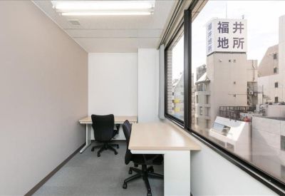Private office suite for two people with desks positioned near a window overlooking the city.