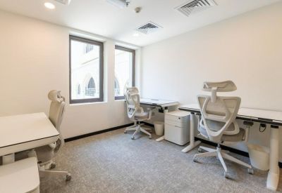 Bright private office suite with three white ergonomic chairs and minimal desks.