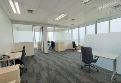 Bright open-plan office space with glass partitions and multiple workstations.