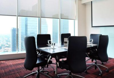 Professional meeting room with a dark wood table, black leather chairs, and expansive city views.