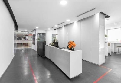 Minimalist white reception desk with orange flower arrangement.