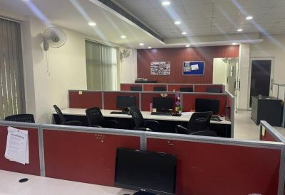 Open-plan workspace with multiple rows of workstations separated by red privacy dividers.