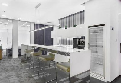 Communal kitchen and break area with marble-top breakfast bar and stools.