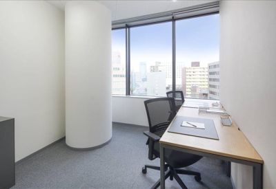Private office suite with a wood-top desk and large windows offering city views.