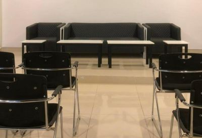 Sleek lounge area featuring black sofas and several small coffee tables.