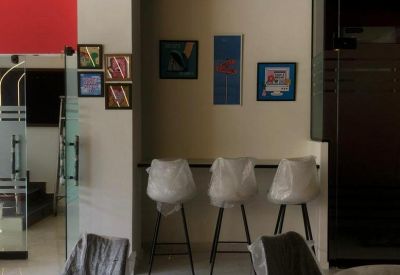 Breakout area with high stools and framed artwork on the wall.