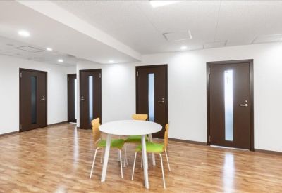 Communal area with a round white table and dark wood doors.