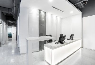 Bright, white minimalist reception area with a sleek illuminated front desk.