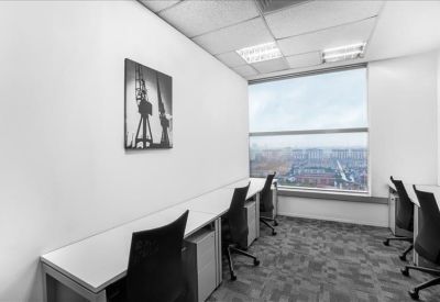 Bright private office suite with four desks and an expansive city view.