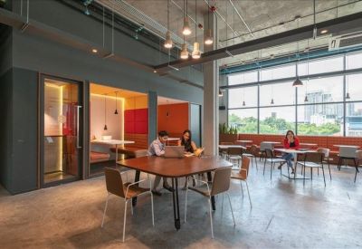 Spacious communal lounge area with a large wooden table and city views through floor-to-ceiling windows.