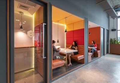 Long white minimalist reception desk with a built-in planter box and modern pendant lighting.