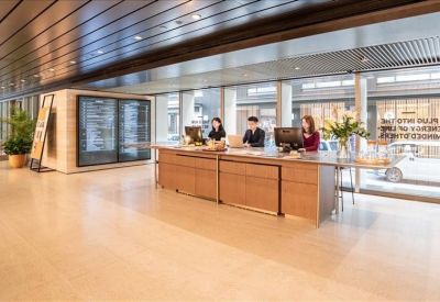 Bright reception desk with wooden panels and staff ready to assist.