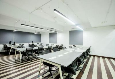 Modern open-plan workspace with rows of desks and striped carpet flooring.
