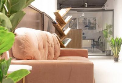 Bright common area featuring a plush pink sofa and creative wooden bookshelf.