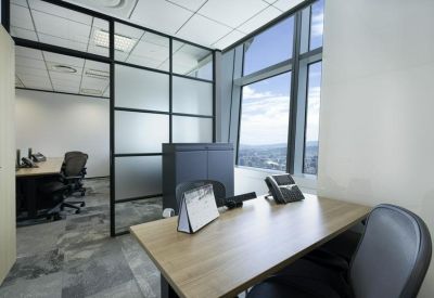 Private office suite with a wood-finish desk and frosted glass partitions.