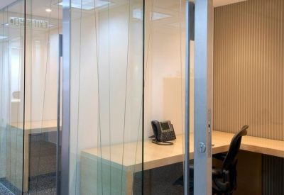 Private office pod with glass partitions and wooden desks.