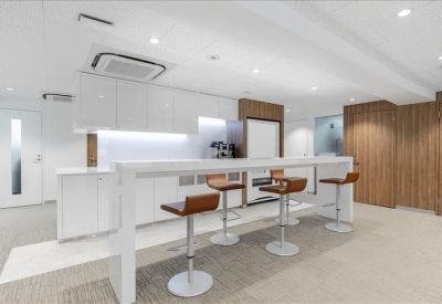 Modern breakout area with white breakfast bar and wood-style stools.
