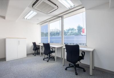 Quiet three-person workspace with white desks and black office chairs.