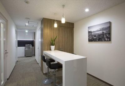 Modern communal break area with a high white bar table and wooden wall paneling.
