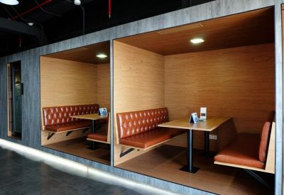 Modern wooden coworking booths with leather seating and warm lighting.