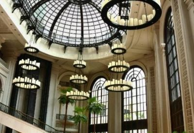 Lush landscaped garden area in front of the building's arched entrance facade.