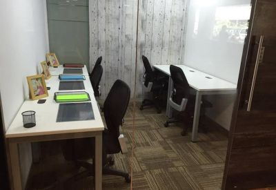 Compact private office suite with two desks separated by a glass partition.