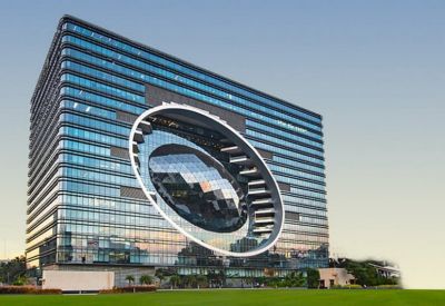 Large contemporary glass building featuring a distinctive circular cutout design.