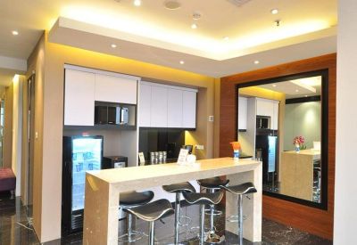Sleek communal kitchen and breakout area with high stools and marble floors.