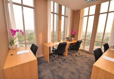 Private office with two desks, ergonomic chairs, and bright window views.