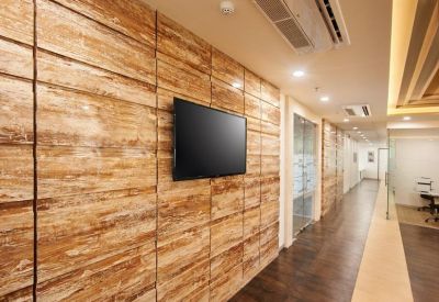 A corridor featuring warm wood-paneled walls and a flat-screen television.