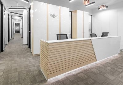 Modern reception desk with wood-slat detailing and a bright corridor.