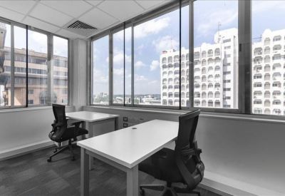 Bright corner office suite with two desks and large windows overlooking the city.