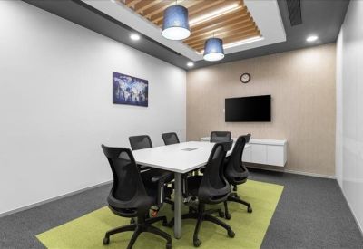 Private meeting room with a white table, ergonomic mesh chairs, and a lime green rug.