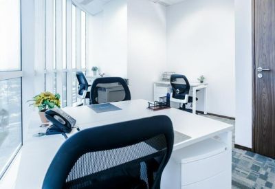 Bright private office suite with two workstations and floor-to-ceiling windows.