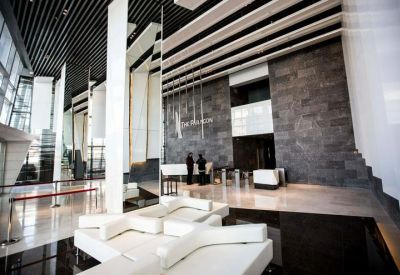 Grand lobby entrance with high ceilings, white pillars, and marble floors.